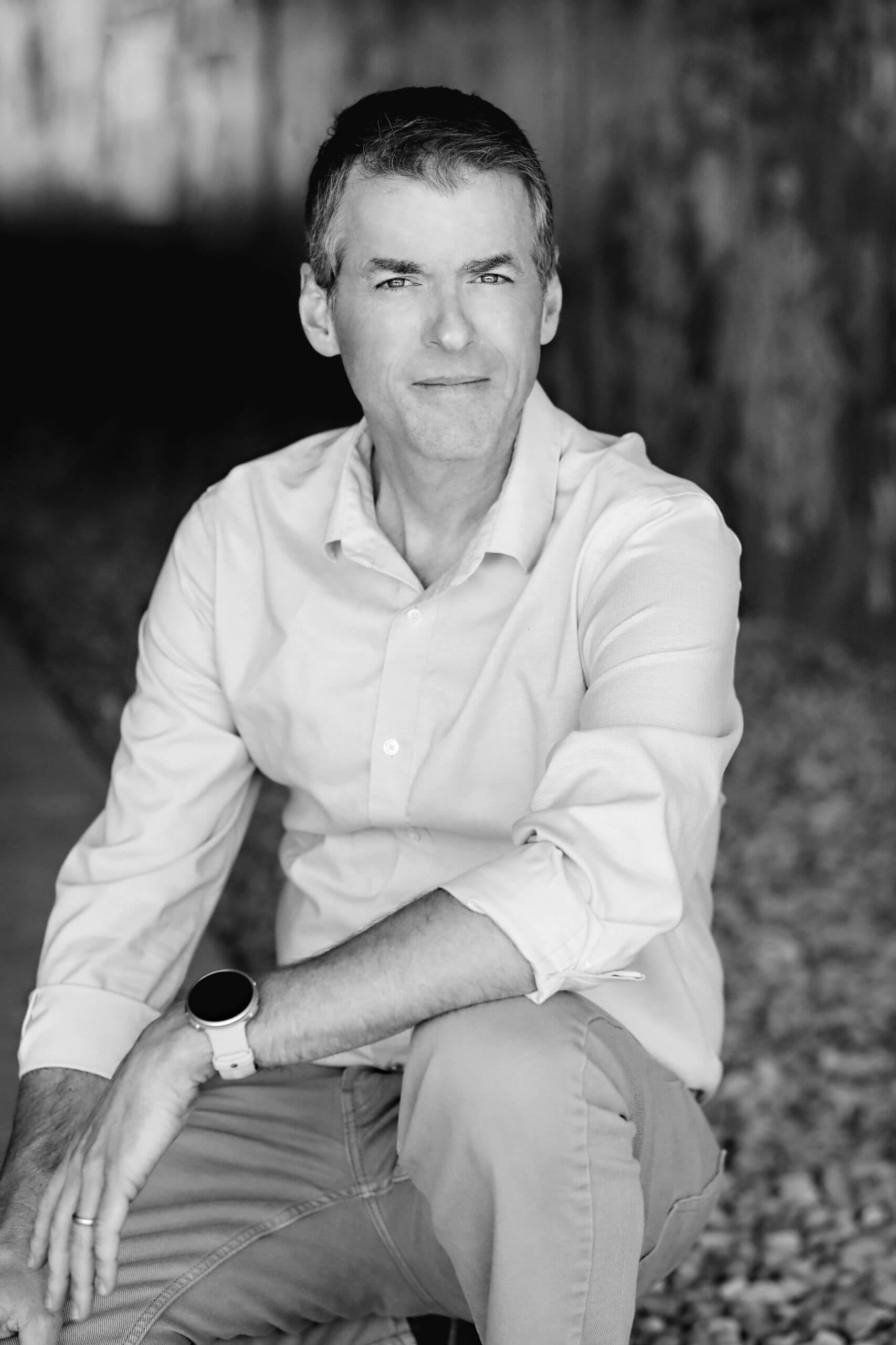 Kevin Williams seated outdoors, forearms resting on a raised knee